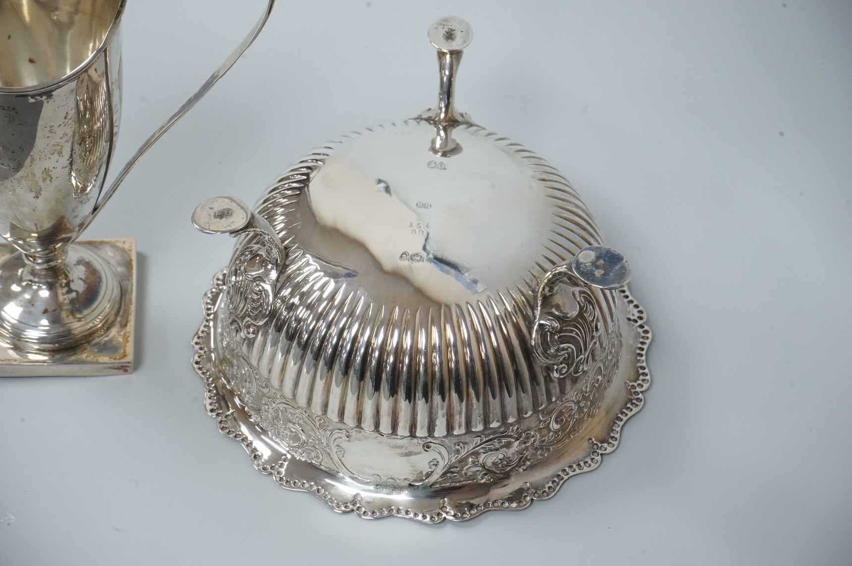 A late Victorian silver sugar basin, by Robert Harper, London, 1879, diameter 13.2cm, together with an Edwardian silver helmet shaped cream jug, Saunders & Shepherd, Chester, 1905, 15cm, 9.1oz.